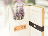 a book wedding menu with letters inside it and some lavender in a pocket is a fun and cute idea