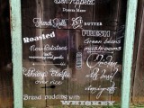 a giant wedding emnu written on an old window is a cool idea for a vintage and rustic wedding