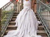 a white mermaid wedding dress with embellishments, a low back, a layered skirt with a long train is a super chic idea