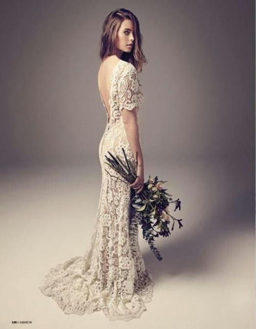 a simple and chic lace sheath wedding dress with short sleeves, a low back and a small train for a summer boho bride