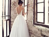 a beautiful A-line wedding dress with a lace bodice on spaghetti straps, a layered skirt with a tulle edge plus a refined top knot for a gorgeous look