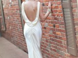 a silk 20s inspired wedding dress with a cowl back, a row of buttons and a train is very chic and shiny