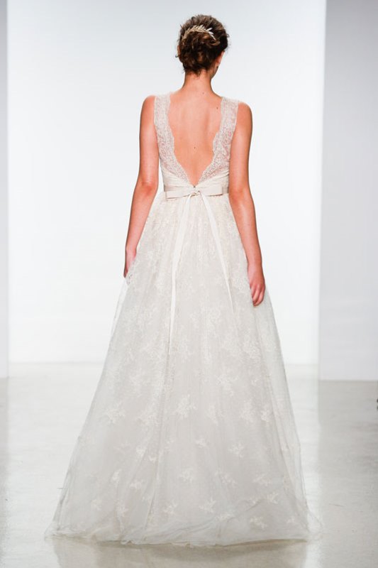 A romantic lace A line wedding balldown with a low back on thick straps, a bow on the back and a skirt wiht a slight train