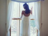 a relaxed layered tulle A-line wedding dress with a cold shoulder, low back and a train for a boho or gypsy bride