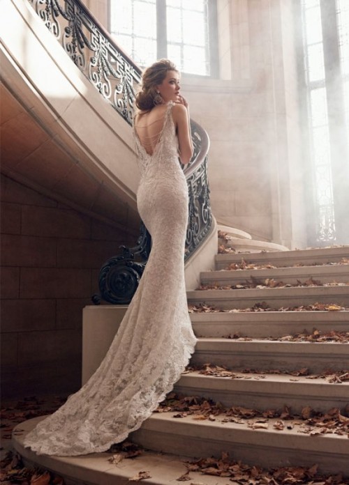 a glam lace mermaid wedding dress with a low back accented with embellished chains and a train is a refined and chic idea