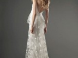 a lace A-line wedding dress with a tiered skirt and a train, a low back and spaghetti straps is very girlish