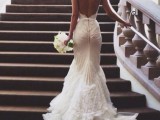 a chic lace mermaid wedding dress with a low back, spaghetti straps and a train with tulle and lace is wow