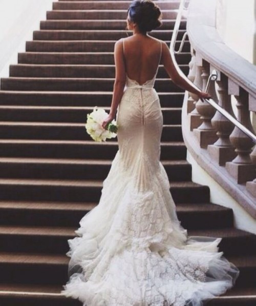 a chic lace mermaid wedding dress with a low back, spaghetti straps and a train with tulle and lace is wow
