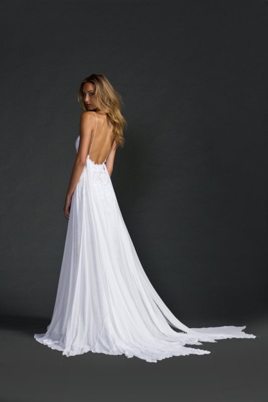 An A line wedding dress   a lace plus plain one, with a low back, spaghetti straps and a train for a flowy boho bridal look