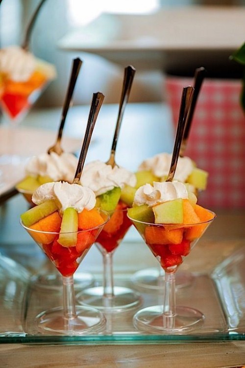 glasses with fresh exotic fruit and whipped cream on top are refreshing and delicious for a summer wedding