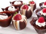 chocolate cups filled with vanilla and chocolate filling and topped with strawberries are refined and very decadent