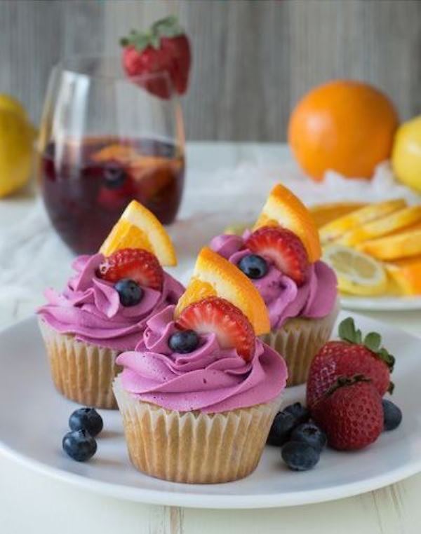 Cupcakes with blueberry icing, fresh blueberries, strawberries and citrus slices are amazing for summer