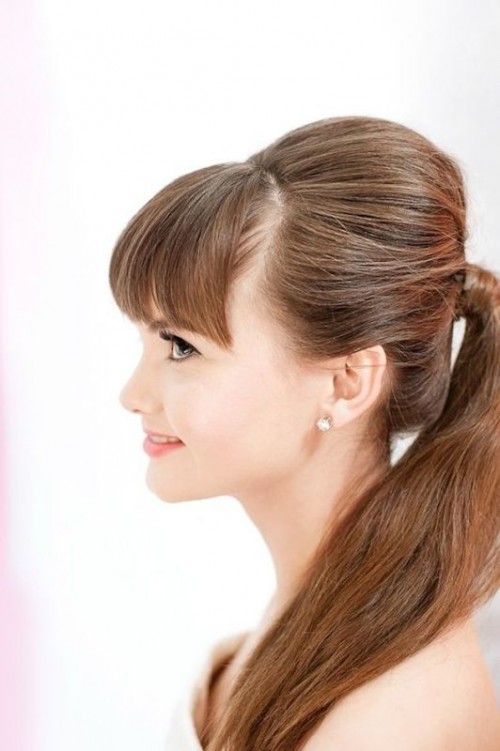 a ponytail with a bump and bangs is a cool idea for cuasl brides who don't want much fuss with their hair