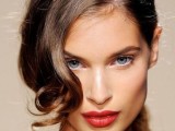 a low curly ponytail with a curled side fringe is a minimalist idea with a touch of romance