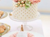 a white wedding cake with gold polka dots, pink sugar blooms, greenery and succulents and berries is amazing for a spring or summer wedding