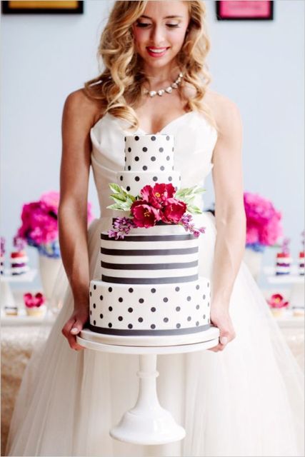 a playful wedding cake with polka dot and striped tiers and fuchsia blooms and greenery is a lovely idea for a spring or summer wedding