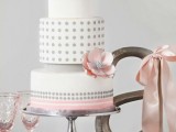 a white, grey and pink wedding cake with polka dot tiers and ribbons painted is a lovely solution for an elegant grey and pink wedding