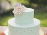 a mint green wedding cake with gold polka dots, a pastel bloom on top is a chic idea for a spring or summer wedding