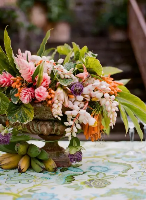 a lush floral centerpiece plus bananas is suitable for a tropical or beach wedding