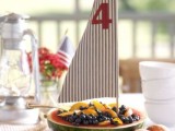 an edible wedding centerpiece with a watermelon and berries plus a sail looks like a boat, and it’s very original
