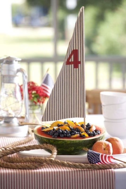 An edible wedding centerpiece with a watermelon and berries plus a sail looks like a boat, and it's very original