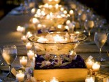 a clear bowl with floating candles and blooms plus candles all around