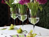 glasses with white and purple tulips and green orchids on the table for a tropical feel