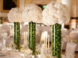 tall clear vases filled with green apples plus white hydrangeas is a creative wedding centerpiece idea