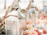 candle lanterns, driftwood and a bright floral garland with pincushion proteas and pink peonies
