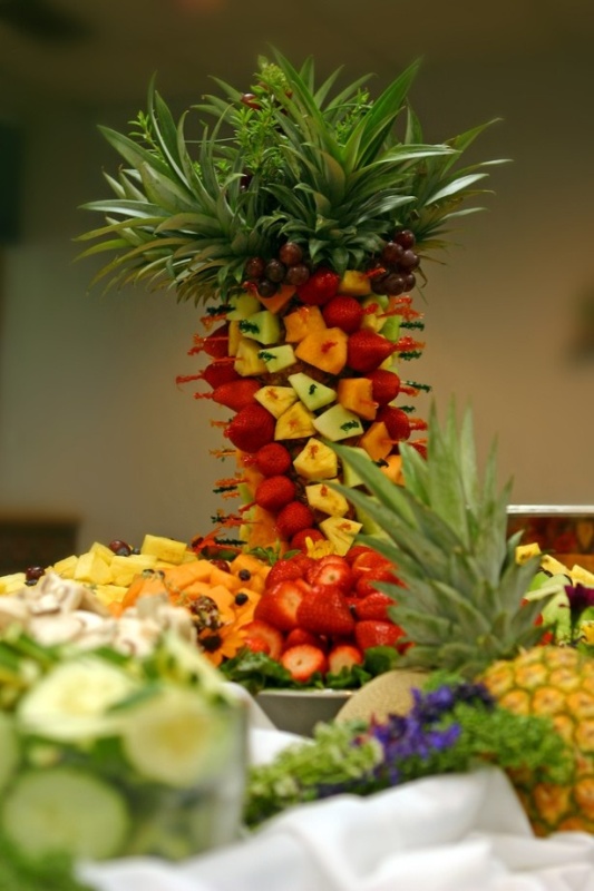 An edible tropical wedding centerpiece composed of tropical fruits creating a tower