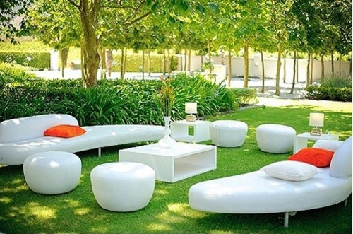 a modern outdoor white lounge with orange pillows that accent the space is a lovely area to spend time in