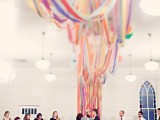 a colorful ribbon wedding backdrop that goes up to the ceiling and creates an installation there is a unique idea
