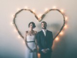 a simple and casual heart wedding backdrop made of reclaimed wood and lights can be easily DIYed by you yourself