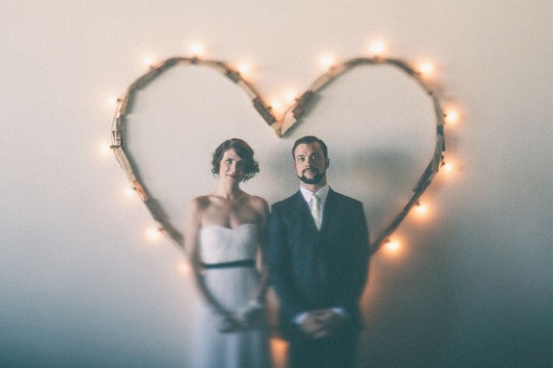 A simple and casual heart wedding backdrop made of reclaimed wood and lights can be easily DIYed by you yourself