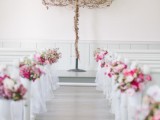 a simple wedding backdrop idea with a sign with vines and pink blooms accentuating the benches is a simple and cute option