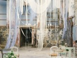 a dreamy wedding backdrop of white flowy and airy fabric hanging down asymmetrically and in various ways