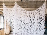 an airy white paper flower wedding backdrop is a beautiful and romantic idea to rock indoors, it can be easily handmade