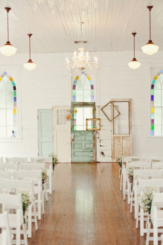 A vintage wedding backdrop composed of several shabby chic doors and frames in different colors is a very relaxed idea