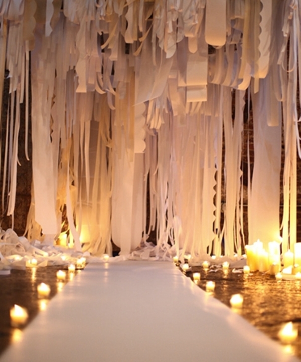 A dreamy white fabric ribbons, fabric and paper ribbons backdrop plus candles on the floor
