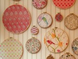 a wedding backdrop made of several embroidery hoops with bright pritned fabric is a cool and fun idea