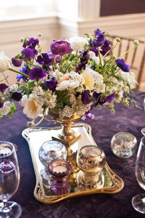 a purple tablecloth and a lush floral centerpiece with purple touches