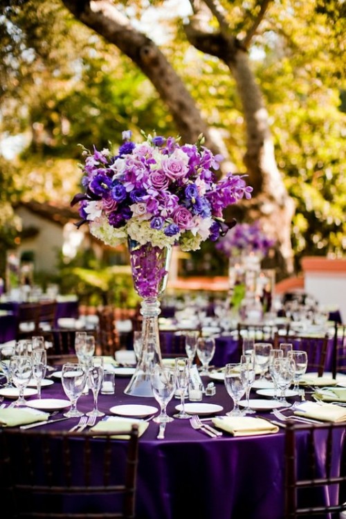 a bright purple tablecloth and a lush bright purple floral centerpiece make up a bold combo