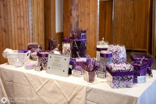 an ivory and purple candy table with various types of candies in bold purple