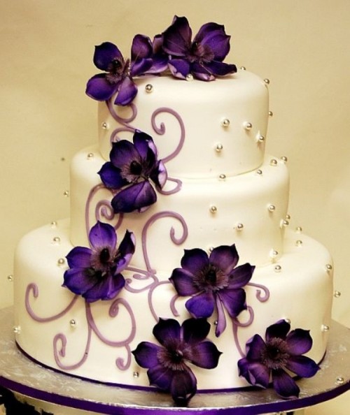 a patterned wedding cake decorated with purple flowers