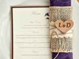 a purple patterned napkin with a burlap napkin ring and a monogrammed heart