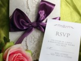 white lace wedding stationery with a silk purple bow
