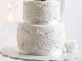 a white lace wedding cake decorated with lace and with a large bloom on top is a great idea for a vintage-inspired wedding