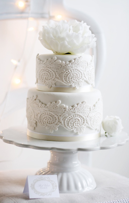 a white lace wedding cake decorated with lace and with a large bloom on top is a great idea for a vintage inspired wedding