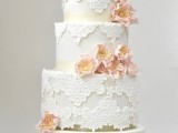 a white lace wedding cake decorated with pink sugar blooms is a beautiful and refined wedding dessert for a vintage celebration
