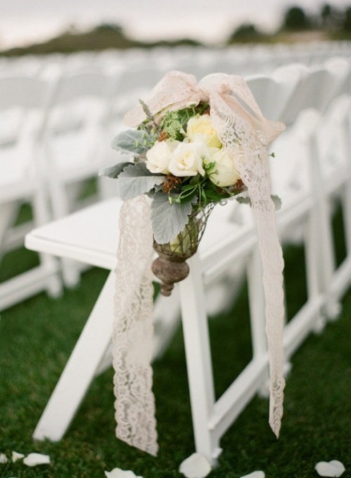 a white flower arrangement with pale greenery and lace ribbon is a beautiful idea for a wedding, it looks chic and lovely